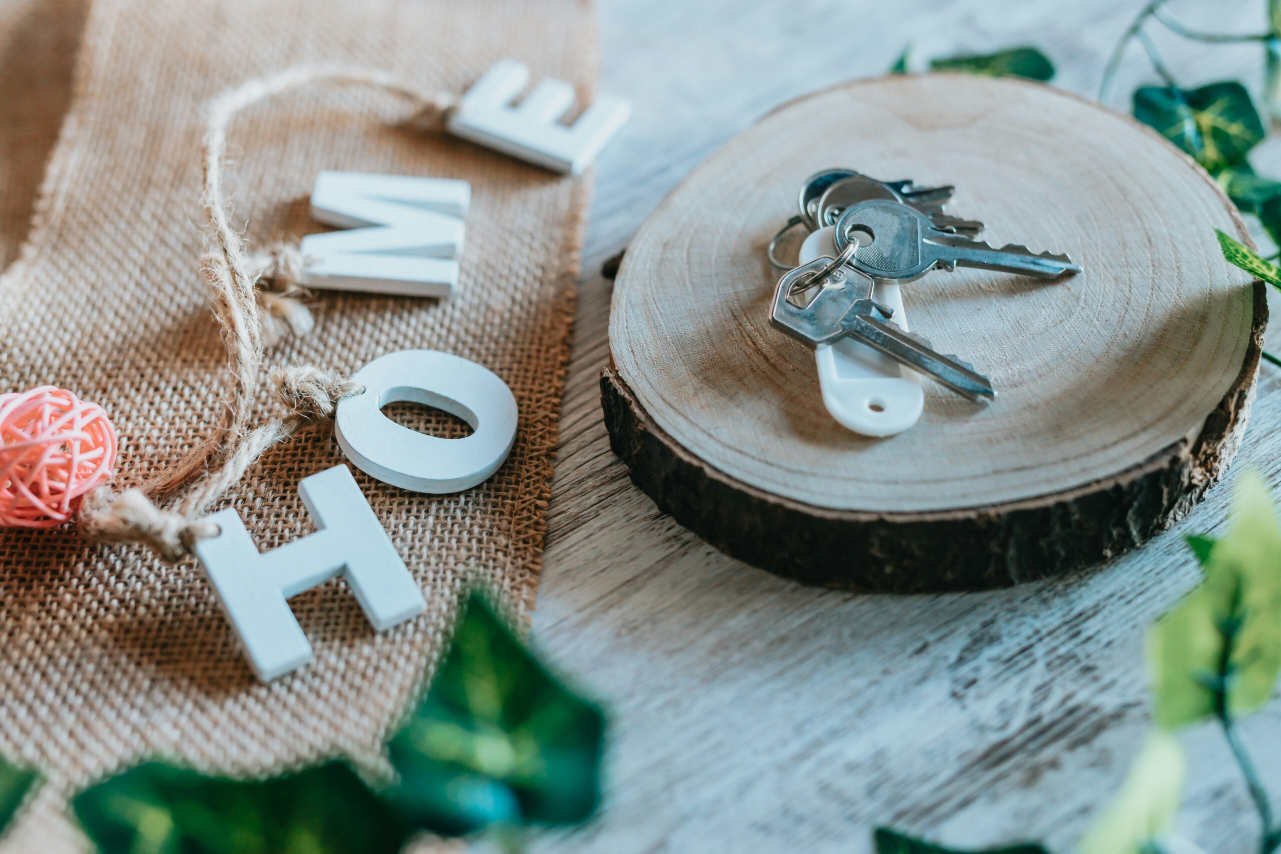 Wooden letter spell out HOME next to keys.